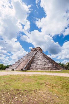 Ancient Mayan Pyramid of Kukulkan at Chichen Itza under a dramatic sky in Mexico.