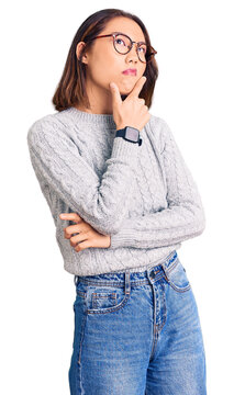 Young beautiful chinese girl wearing casual clothes thinking worried about a question, concerned and nervous with hand on chin
