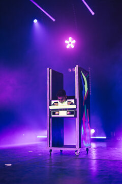 Magician doing illusion trick on illuminated stage