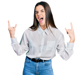 Young brunette teenager wearing business white shirt shouting with crazy expression doing rock symbol with hands up. music star. heavy concept.