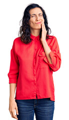 Young beautiful hispanic woman wearing casual clothes touching mouth with hand with painful expression because of toothache or dental illness on teeth. dentist