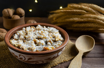 Kutya, a traditional Christmas Ukrainian dish of wheat groats on the table for Christmas or the old new year. Boiled porridge with walnuts, raisins, poppy seeds and honey. Rustic style.