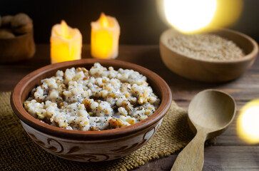 Kutya, a traditional Christmas Ukrainian dish of wheat groats on the table for Christmas or the old new year. Boiled porridge with walnuts, raisins, poppy seeds and honey. Rustic style.