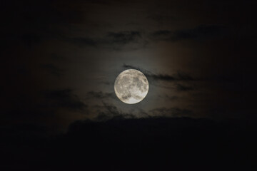 full moon shining through the clouds