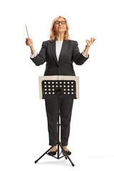 Full length portrait of a female conductor directing an orchestra
