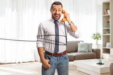 Man tied with a rotary phone cable at home