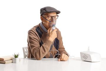 Elderly man sitting on a table and using a nebuliser