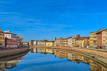 Fototapeta na wymiar Pisa, Italy - view of the Arno River as seen from the Ponte di Mezzo bridge with the historic buildings of Lungarno Pacinotti