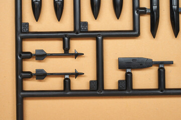 Closeup of various black plastic model parts on a sprue for scale modeling