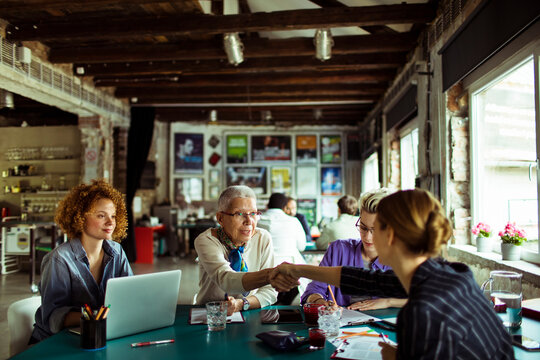 Multigenerational diverse group of woemn working on a project in a startup company office