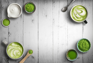 Matcha latte and green tea powder ingredients on wood background with copy space