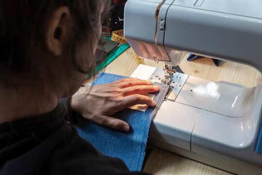 Sewing denim on a machine with skilled hands