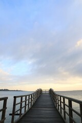 Obraz premium Wooden boardwalk with gulls by the ocean. 