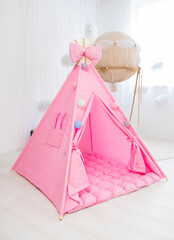 Playroom with Teepee. Modern room interior with play tent for child. pink children's wigwam in the room on the floor Scandinavian style with decor. High quality photo © Nataliia