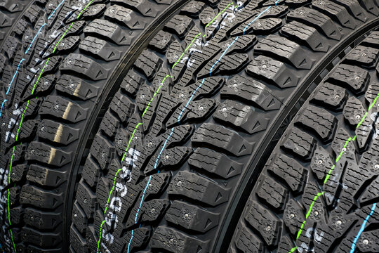 Studded new winter tires background, snow tires with metal studs