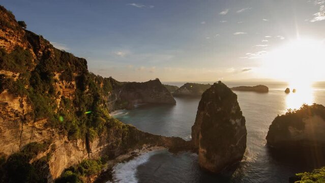 Mountains and ocean video timelapse for background. Sunrise on Diamond Beach, the famous place on the Bali, Nusa-Penida, Indonesia. The sky with running clouds. Twilight turns into complete morning