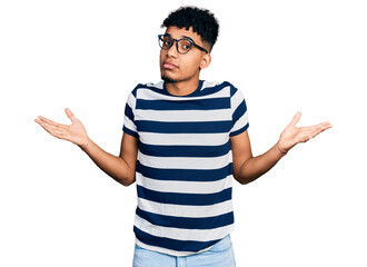 Young african american man wearing casual clothes and glasses clueless and confused expression with...