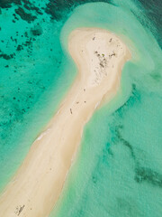Drone shot over a tropical beach with blue water