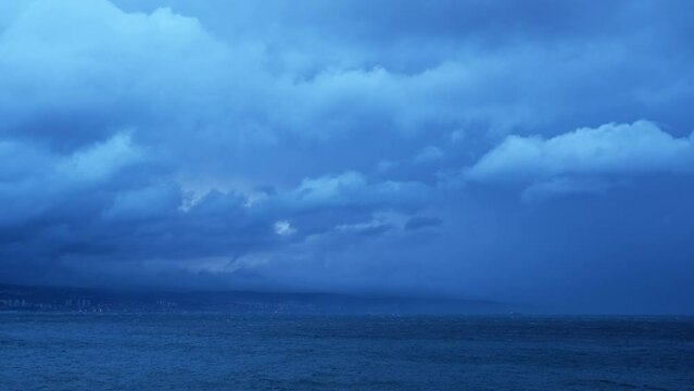 Real time fluffy tropical storm clouds moving above the sea on a windy morning. Magnificent nature landscape in blue hour. Relaxing or meditative, continuously changing cloudscapes for background.