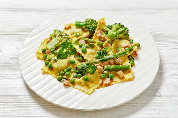 ravioli primavera with ham on a white plate