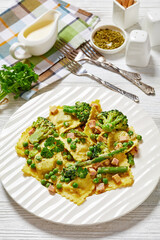 ravioli primavera with ham on a white plate