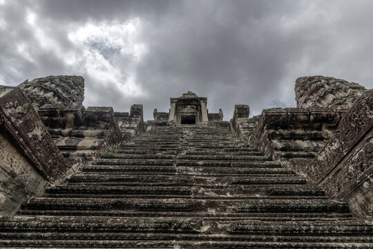 Dramatic sky over ancient Angkor Wat temple staircase