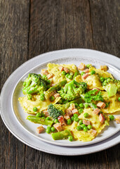 ravioli primavera with ham on a grey plate
