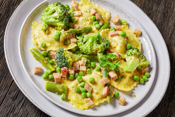 ravioli primavera with ham on a grey plate