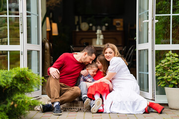 Beautiful and happy family on the porch of the house. 