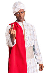 African handsome man wearing tradition sherwani saree clothes showing middle finger, impolite and rude fuck off expression