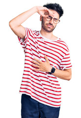 Young hispanic man wearing casual clothes touching forehead for illness and fever, flu and cold, virus sick