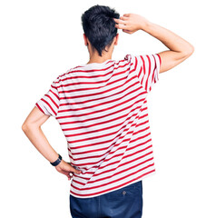 Young hispanic man wearing casual clothes backwards thinking about doubt with hand on head