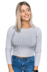 Obraz premium Beautiful blonde woman wearing casual clothes looking away to side with smile on face, natural expression. laughing confident.