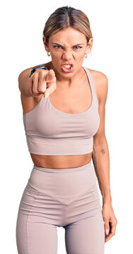 Beautiful caucasian woman wearing sportswear pointing displeased and frustrated to the camera, angry and furious with you