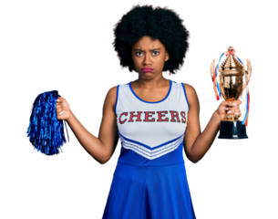 Young african american woman wearing cheerleader uniform holding pompom and trophy skeptic and nervous, frowning upset because of problem. negative person.