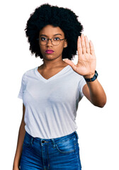 Young african american woman wearing casual white t shirt doing stop sing with palm of the hand....