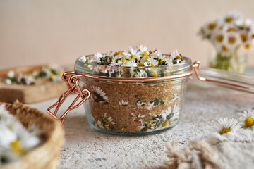 Making homemade herbal syrup from common daisy flowers and cane sugar