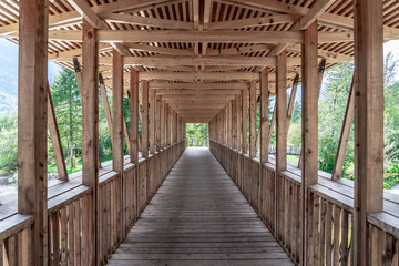 Symmetrical picture of the walkway of the wooden bridge over the river, Slovenia