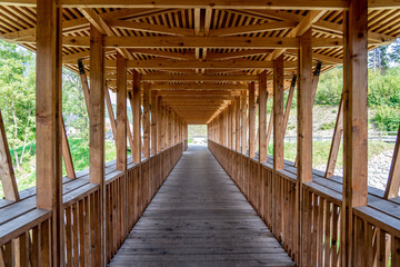 Symmetrical picture of a wooden bridge over a river, Slovenia