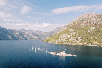 Sailing regatta sails to the island of Gospa od Skrpjela in the Bay of Kotor. Montenegro. Drone