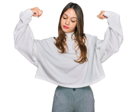 Young brunette woman wearing casual turtleneck sweater showing arms muscles smiling proud. fitness concept.