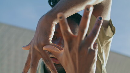 Charismatic dancer improvising portrait. Dreads man moving hands closeup