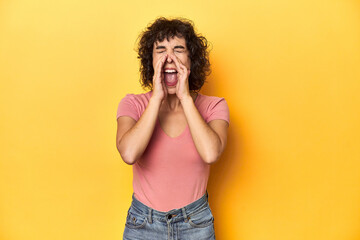 Curly-haired Caucasian woman in pink t-shirt shouting excited to front.