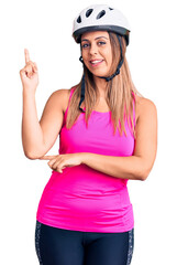 Young beautiful woman wearing bike helmet smiling happy pointing with hand and finger to the side