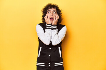 Curly-haired Caucasian woman in baseball jacket whining and crying disconsolately.