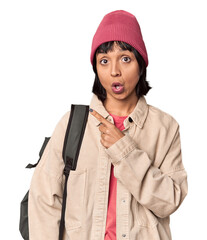 Young student with backpack and beanie in studio trying to listening a gossip.