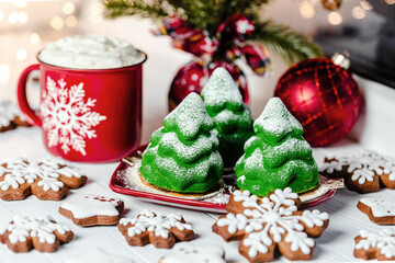 Sweet Christmas tree cakes, Christmas cookies and a Christmas mug on the windowsill.