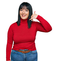 Young hispanic woman wearing casual clothes smiling doing phone gesture with hand and fingers like talking on the telephone. communicating concepts.