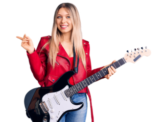 Young beautiful blonde woman playing electric guitar smiling happy pointing with hand and finger to the side