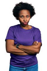 African american woman with afro hair wearing casual purple t shirt skeptic and nervous,...